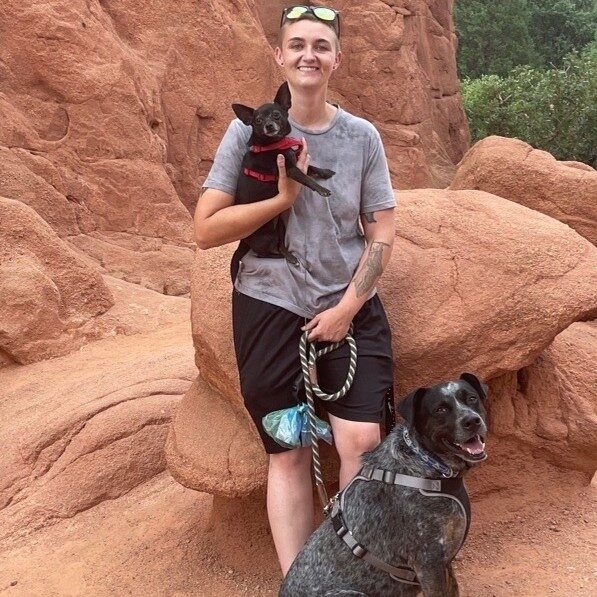 smiling woman hiking with her two dogs