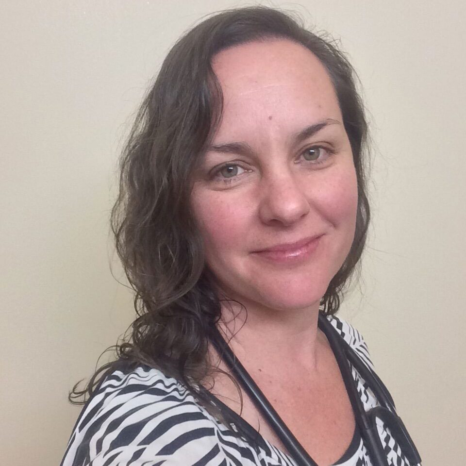 smiling female veterinarian with wavy brown hair
