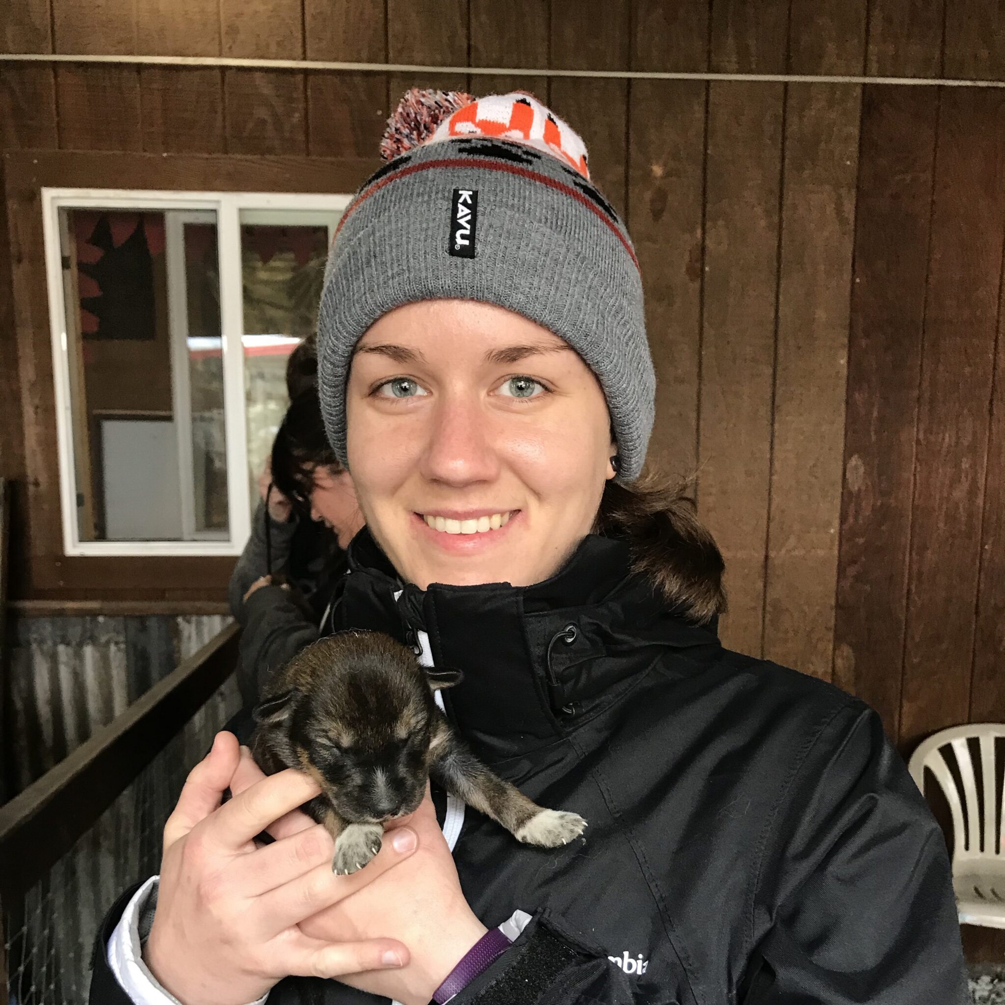 smiling woman holding a puppy